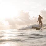 女性サーファーがBeach Access Standard 9'0" ピンテール ロングボードで波をライディングする様子