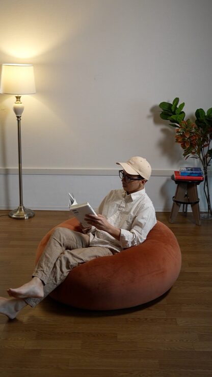 テラコッタのYURUMARUに座って本を読む様子